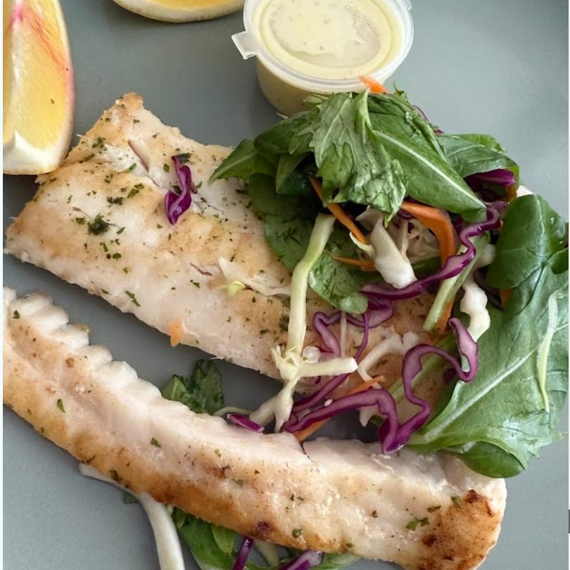 Grilled fish served with fresh greens